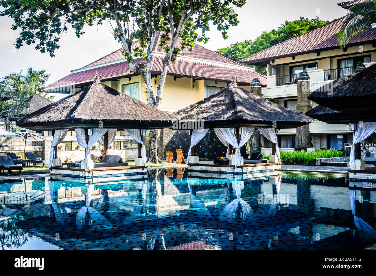 swimming pool and poolside cabana with lounge chairs and lounge beds