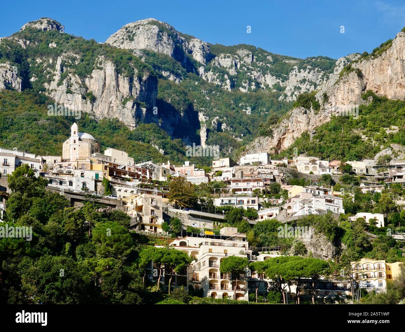 Catholic Church Madonna delle Grazie, Our Lady of Graces, and terraced homes, villas, buildings against backdrop of Amalfi hillside, Positano, Italy. Stock Photo