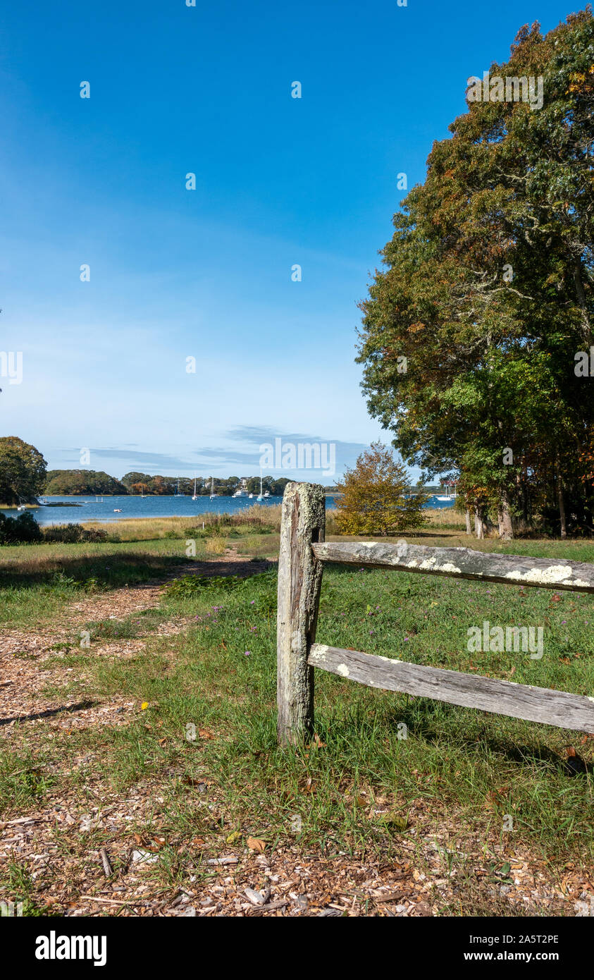 Path to a Cape Cod harbor on Conservation Trust land with wood split