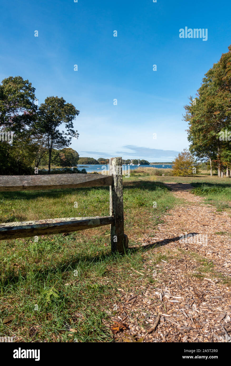Path to a Cape Cod harbor on Conservation Trust land with wood split rail fence Stock Photo