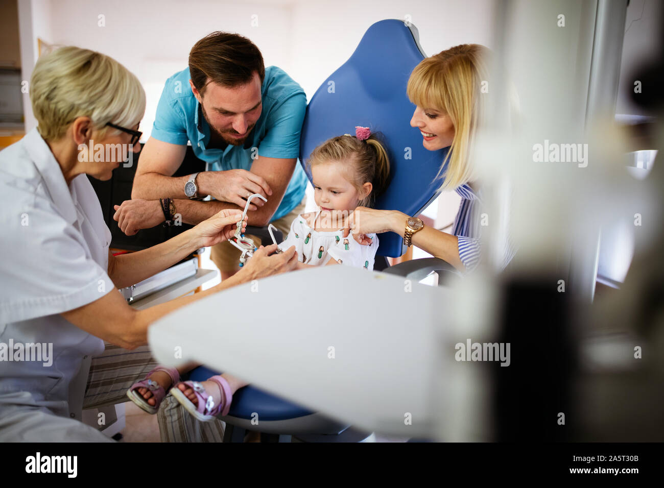 Ophthalmologist is checking the eye vision of little cute girl in modern clinic. Stock Photo