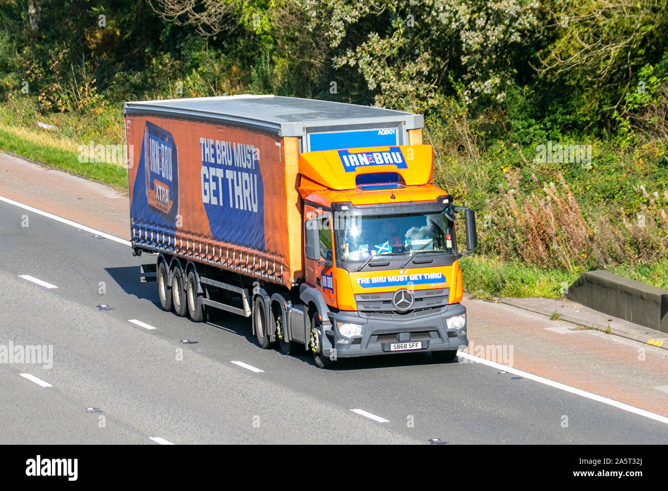IRN BRU must get thru Haulage delivery trucks, lorry, transportation, truck, cargo, Mercedes Benz vehicle, food delivery, commercial transport, drinks industry, supply chain freight, on the M6 at Lancaster, UK Stock Photo
