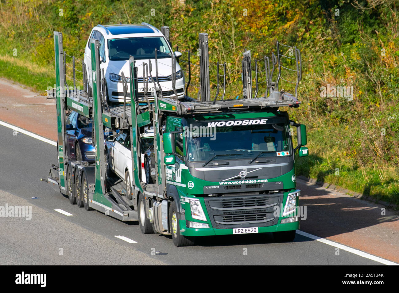 Woodside car carrier; Haulage delivery trucks, lorry, transportation, truck, cargo, green Volvo FM  vehicle, delivery, commercial transport, industry,  collection and deliveries on the M6 at Lancaster, UK Stock Photo
