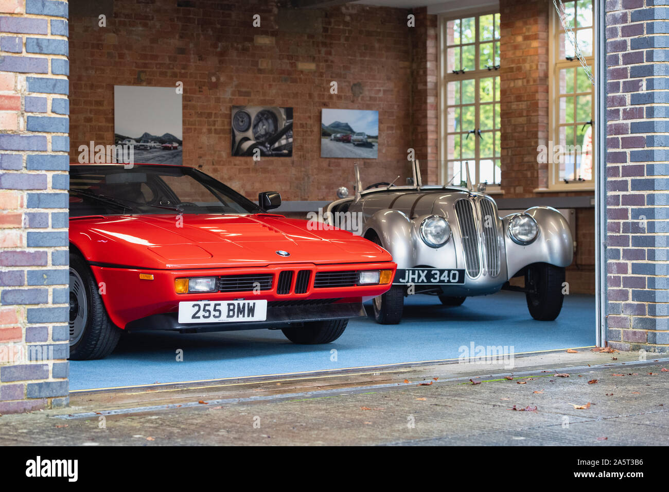 1981 BMW M1 and 1933 BMW Fraser Nash in a workshop at Bicester Heritage Centre sunday scramble event. Bicester, Oxfordshire, England Stock Photo