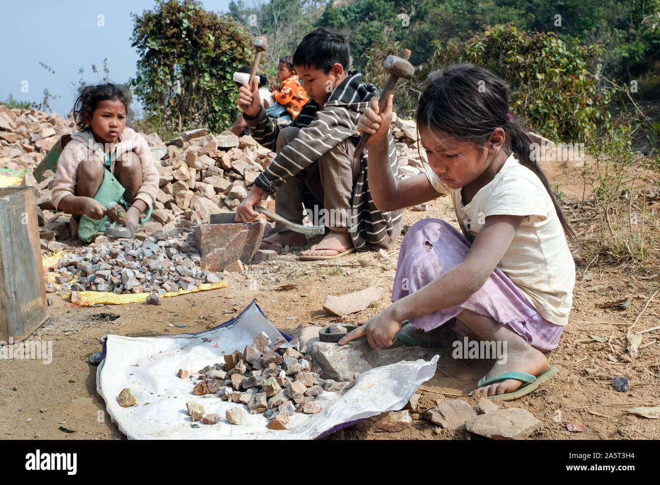 Children are employed to crush stones for road constructions (girls 6