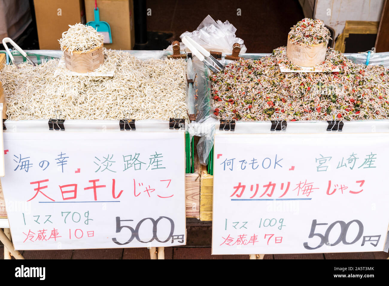 Tiny dried fish displayed outside store in Sugamo, Tokyo. Called Chirimen juako or Shirasu Boshi. Two wooden plastic lined boxes full of fish. Stock Photo