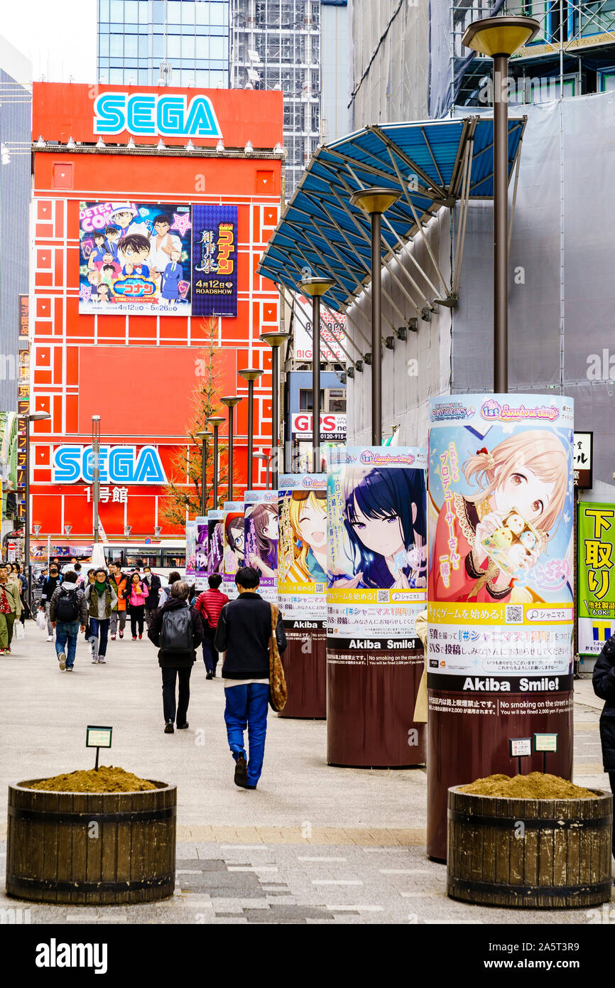 Tokyo, Akihabara, electric town. View along a row of round stands with Akiba smile campaign posters on, in front of the iconic red Sega building. Stock Photo