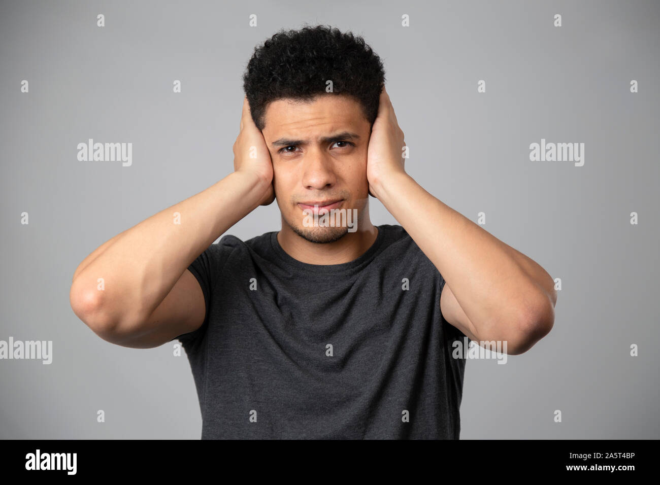 Hispanic man smiling in studio with gray background Stock Photo