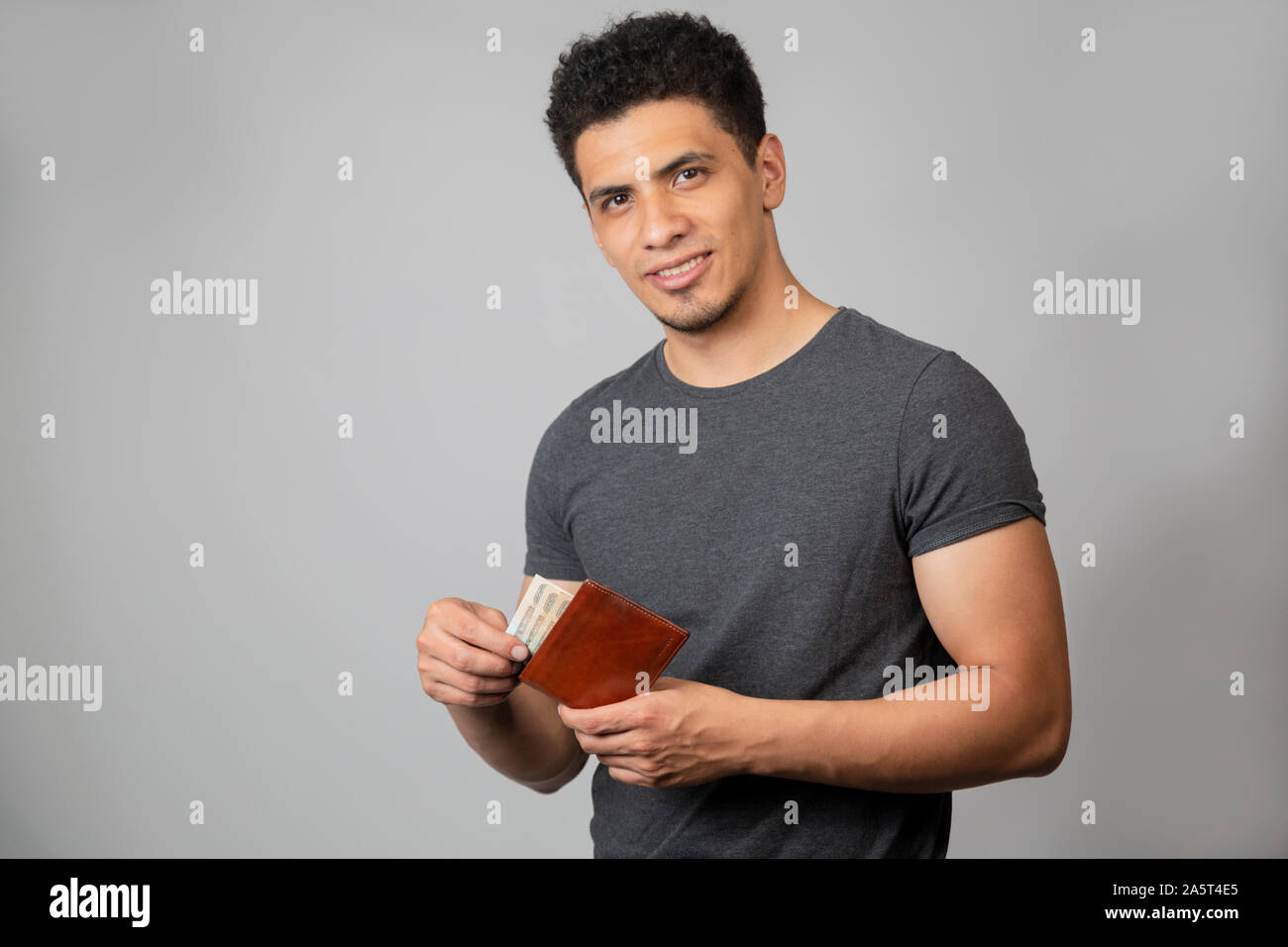 Hispanic man smiling in studio with gray background Stock Photo