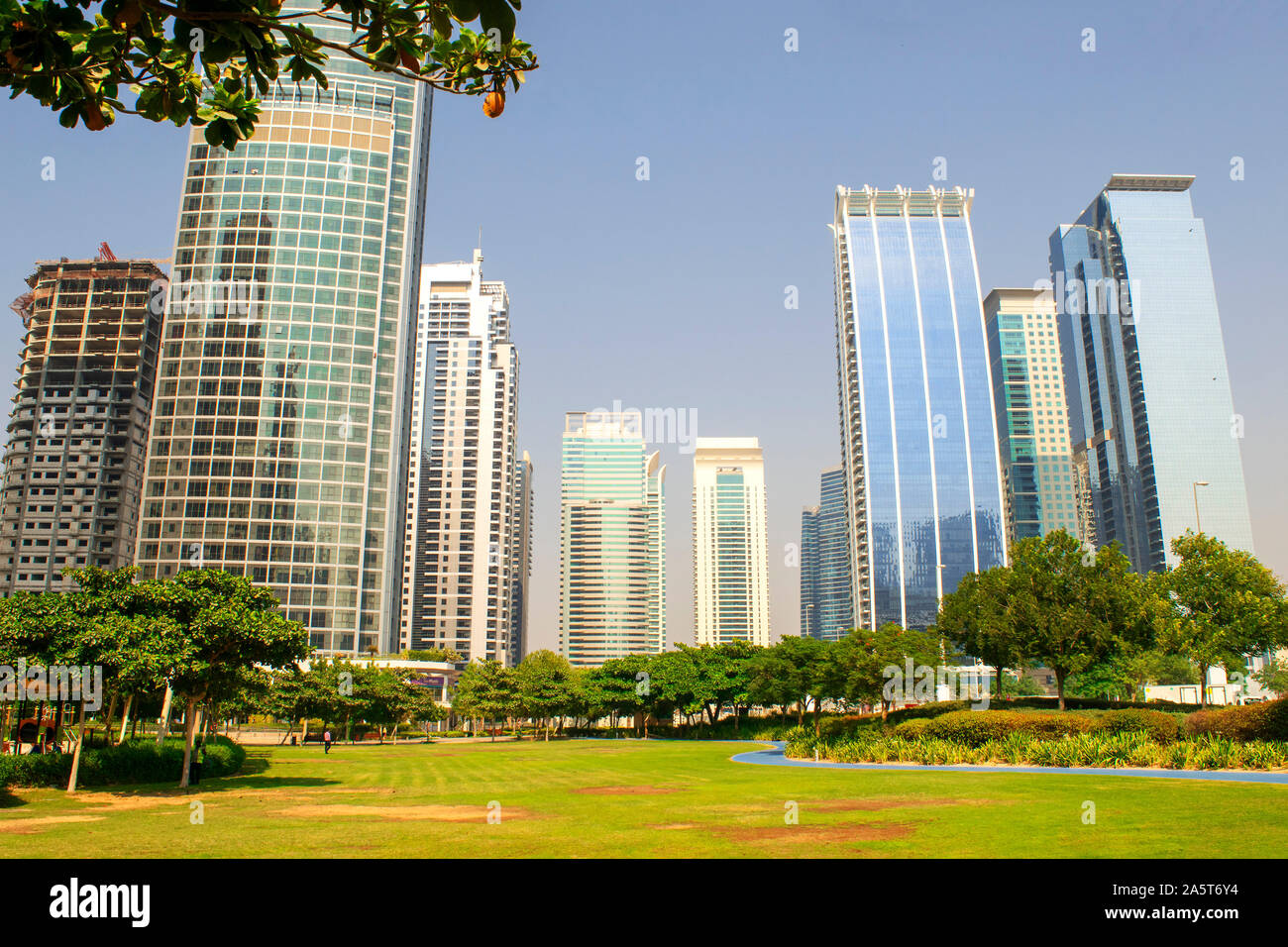 Dubai / UAE - October 15, 2019: View of Jumeirah Lakes Towers skyscrapers and park. Residential buildings covered with glass in JLT. Dubai park. Stock Photo