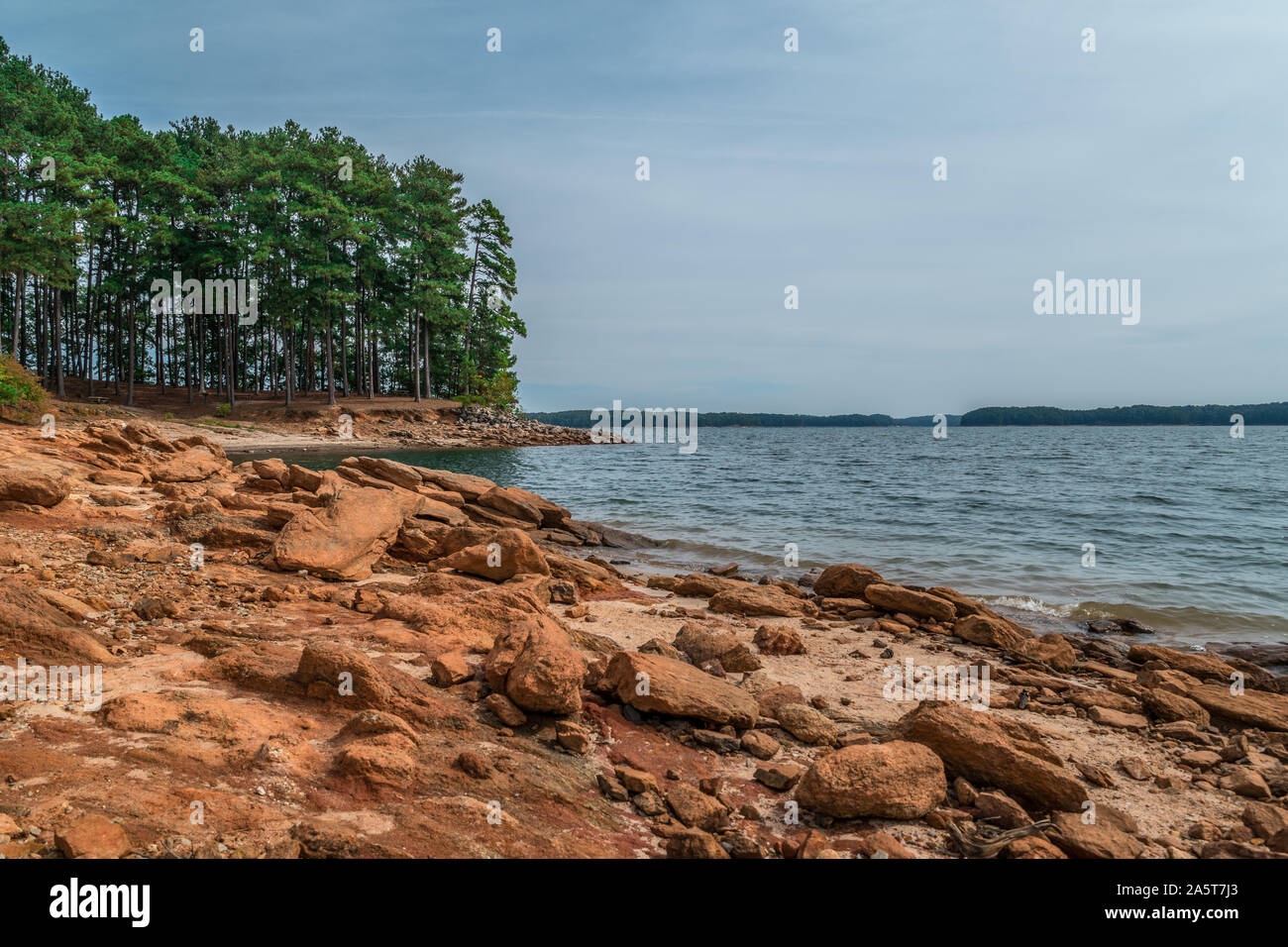 Severe drought conditions at Lake Lanier, Georgia eroding the shoreline exposing the rocks and boulders on a sunny day in fall Stock Photo