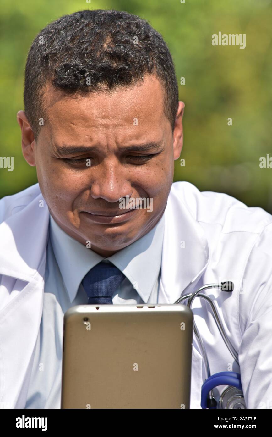 Distraught Male Doctor Using Tablet Stock Photo