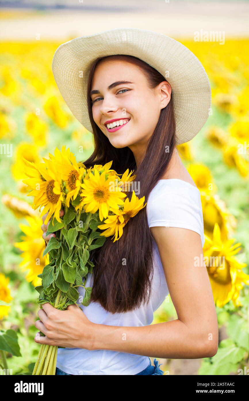 Close up portrait of a young beautiful girl in a field of sunflowers ...