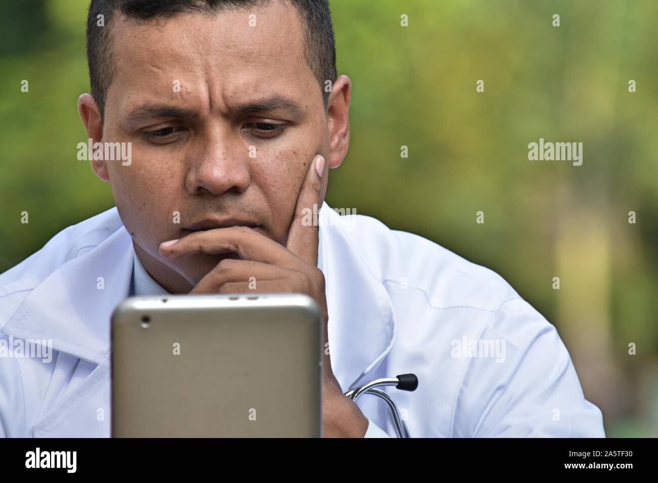 Thinking male doctor using tablet stock photo alamy