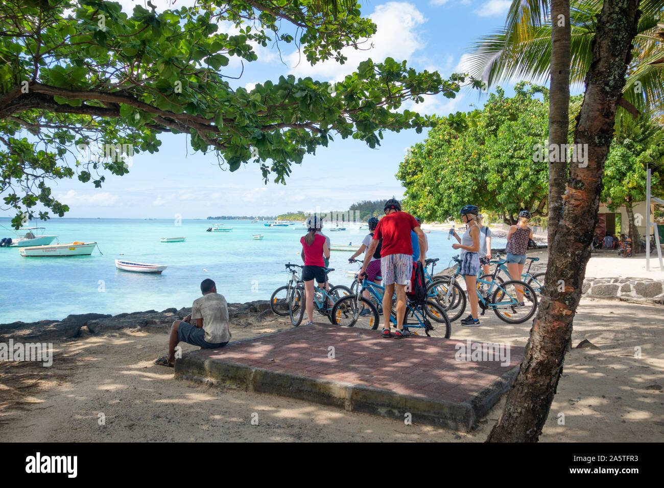 Mauritius cycling; a bicycle tour group of tourists by the beach, Trou aux Biches, Mauritius Stock Photo