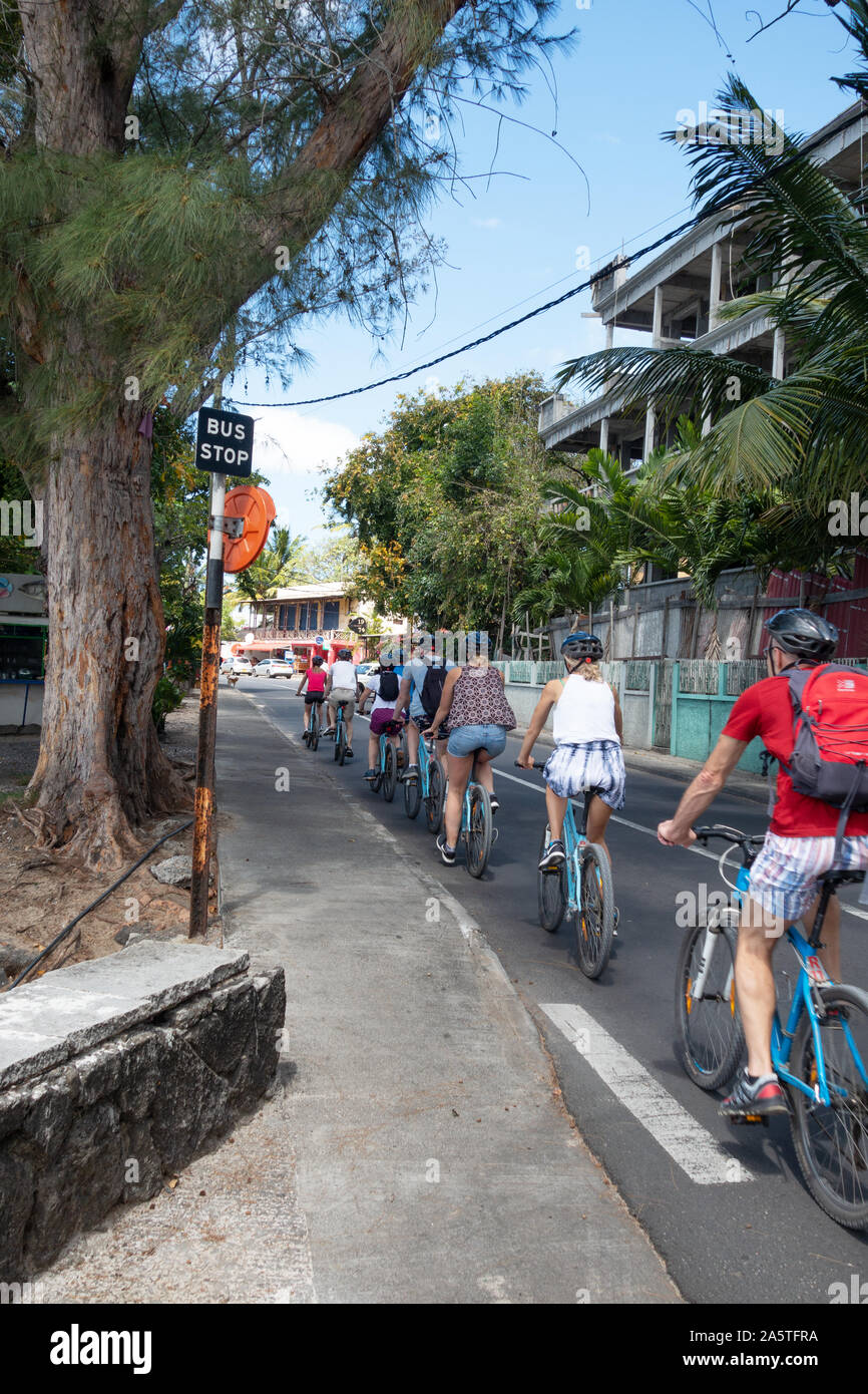 Mauritius cycling holiday - a tourist group cycling in a town in north Mauritius, Stock Photo