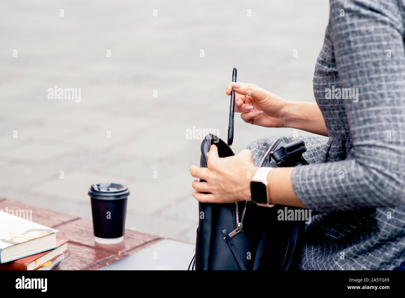 Pencil Inbackpack Student girl puts ballpoint pen into black backpack on bench. Girl's ...