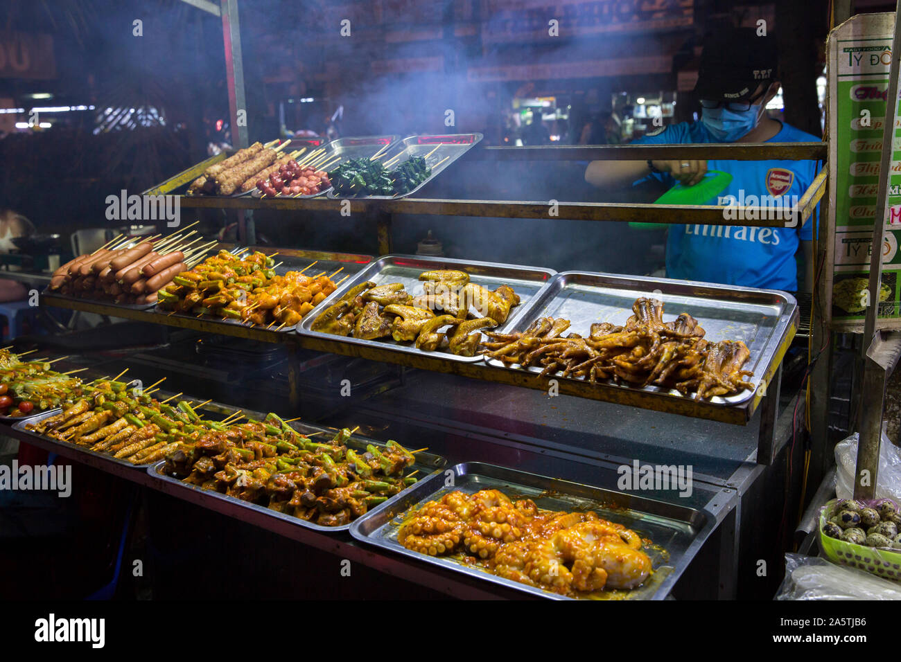 Cooked mat and seafood are displayed at a night market in Vietnam. Stock Photo