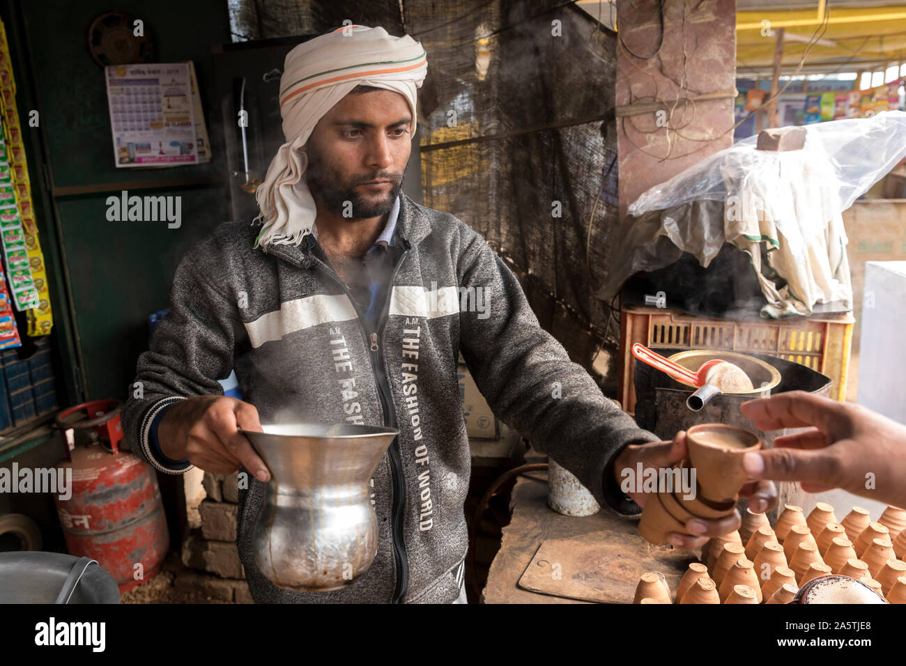 A  Rajasthani 'Chaiwalla' hands over tea in a traditional clay cup. Stock Photo