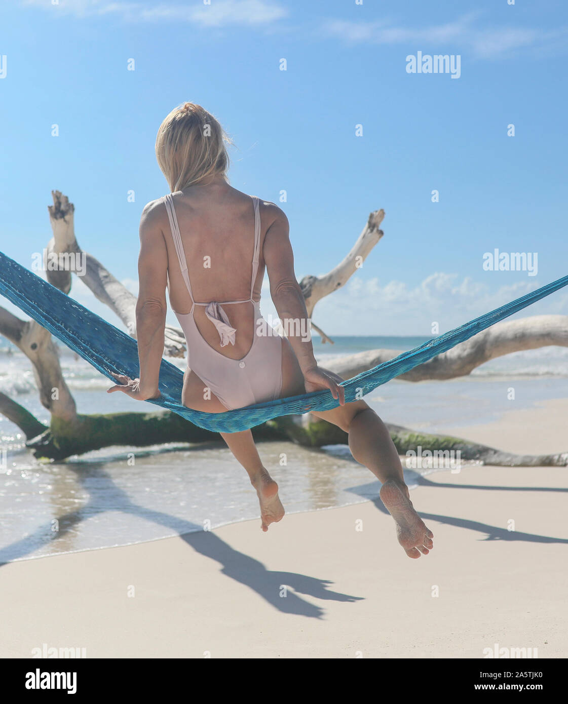 Fit woman from behind on beach in hammock Stock Photo