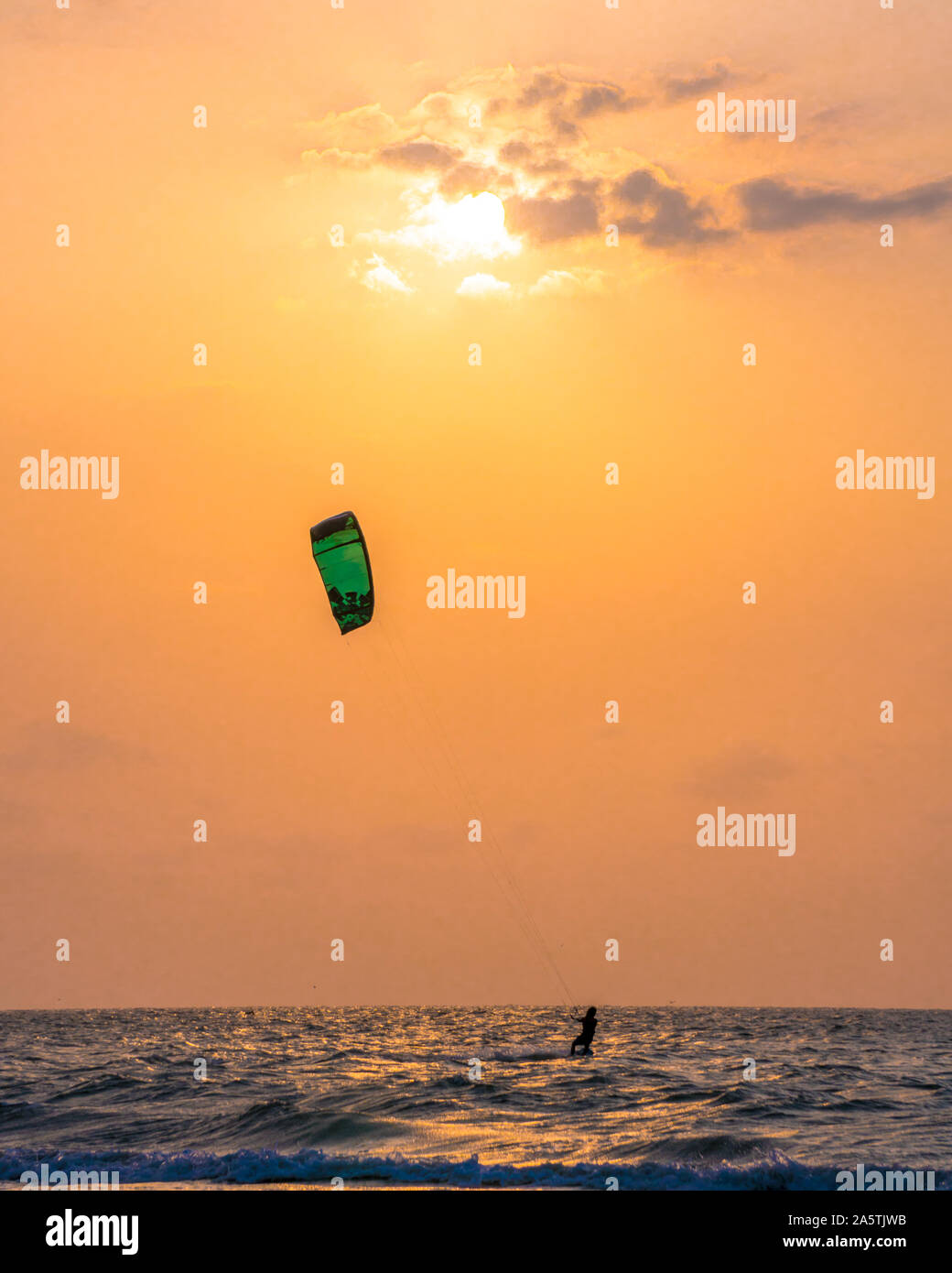 puesta de sol mientras practican kitesurfing en la playa Stock Photo