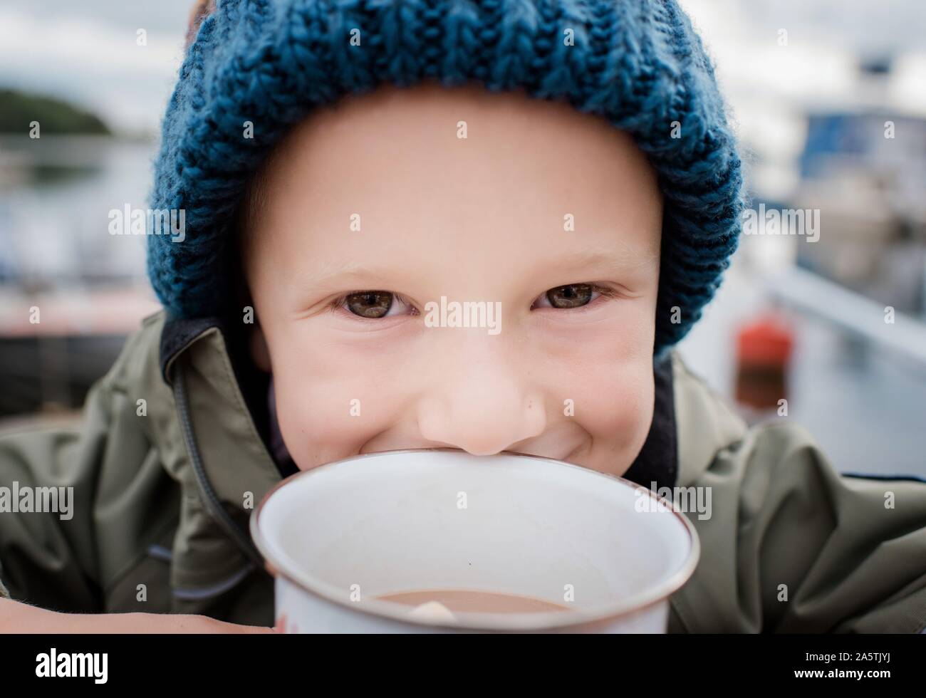 close up portrait of a boy drinking hot chocolate outside camping Stock Photo