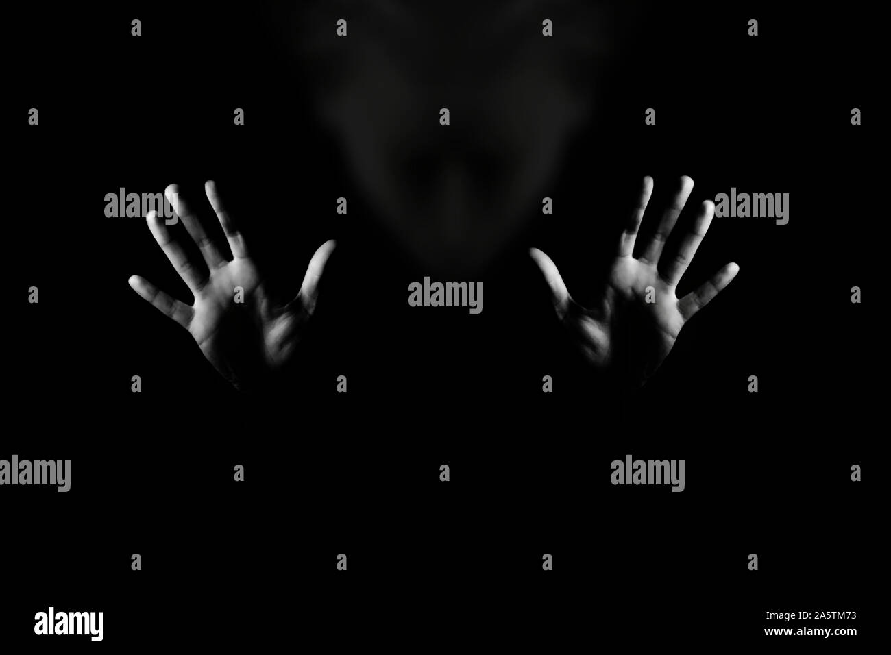 Woman showing gesture stop by hand. Violence against women concept or horror background. Black and white studio shot. Stock Photo