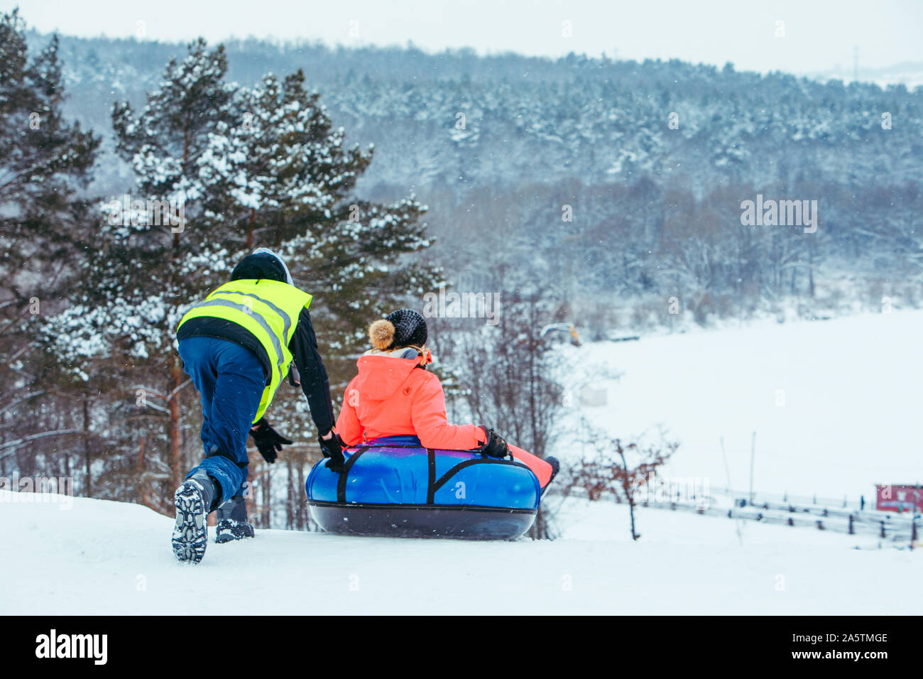 winter fun activities. ride down by hill on snow tubing Stock Photo Alamy