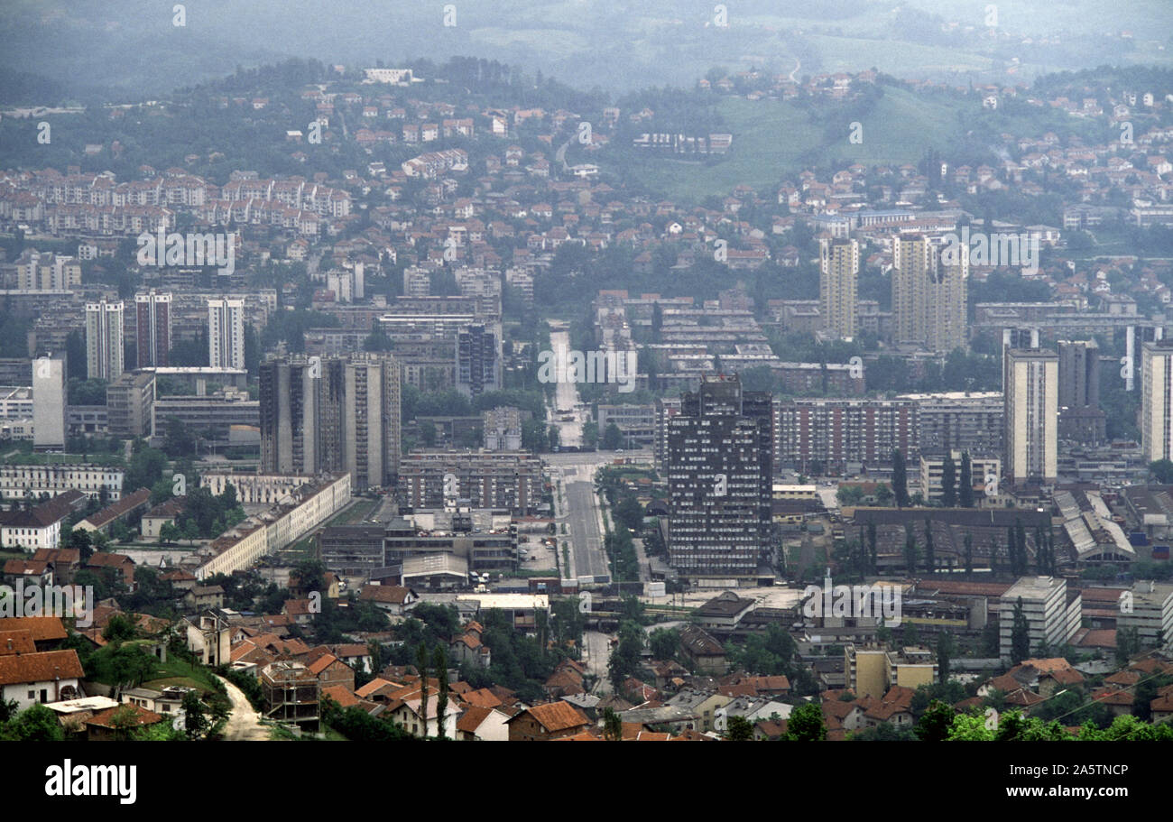 6th June 1993 During the Siege of Sarajevo: the view south from Hum Hill along Hamdije Čemerlića Street, known as Bratstva i Jedinstva (the street of 'Brotherhood and Unity') during the war. The street crosses Sniper Alley and the Miljacka River, into Bosnian-Serb-held Grbavica. At various points lorries and containers act as sniper barriers. Stock Photo