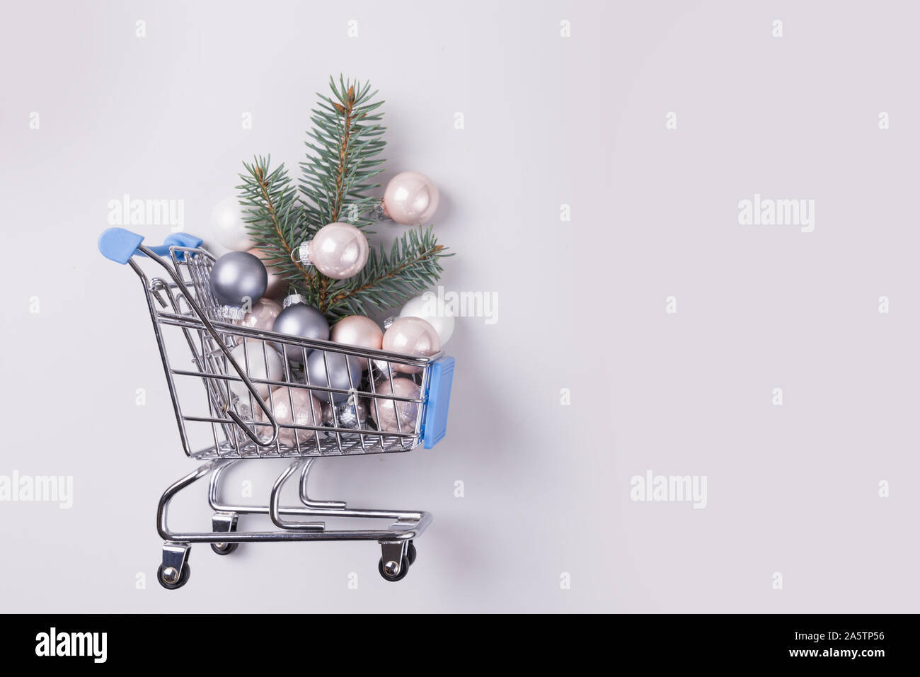 Christmas sale, shopping concept - trolley cart full of balls and xmas tree. Preparation to holiday and boxing day. Top view. Space for text. Stock Photo