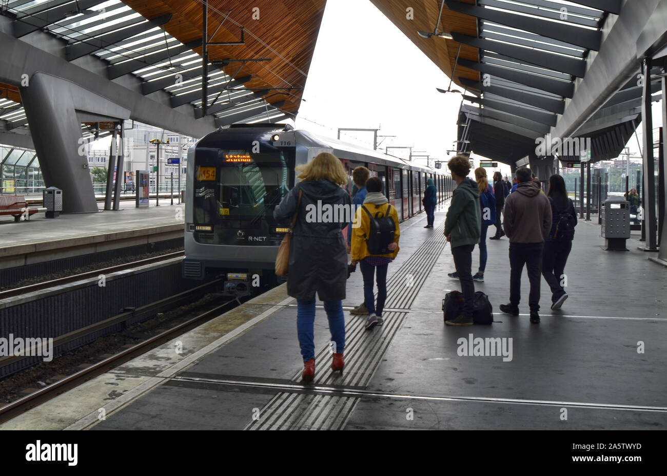 Amsterdam, Holland, August 2019. Inside the metro station bijlmer arena, travelers wait for the train on the quay. Modern structure with steel and woo Stock Photo