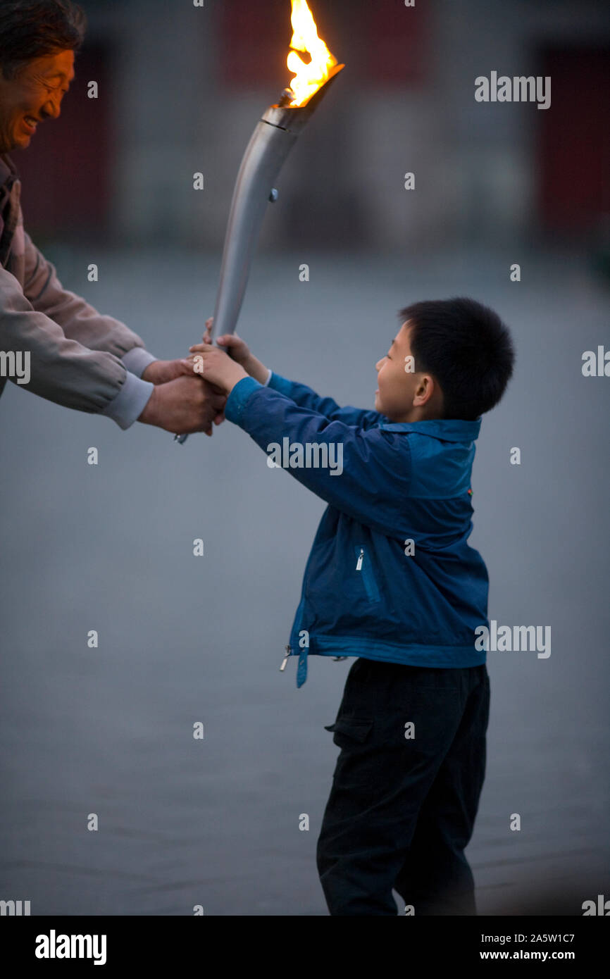Young boy carrying an Olympic torch in a park Stock Photo Alamy
