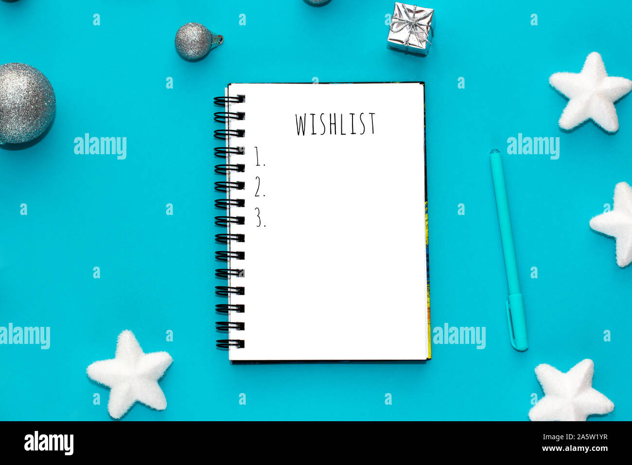 Notebook with wish list on mint green background. Top view. Stock Photo