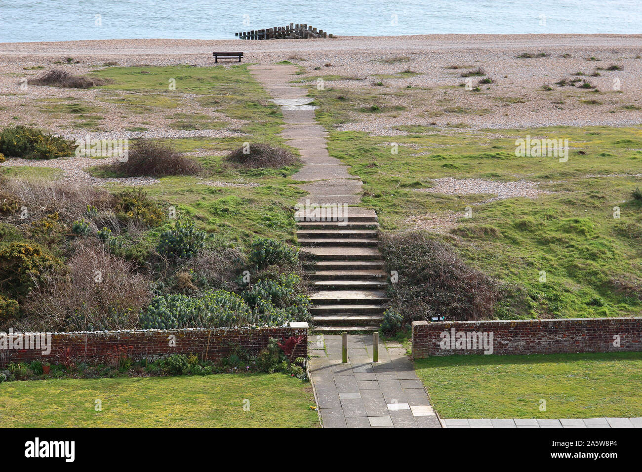 View from a Martello tower (number 61) of the pathway onto the shingle beach at Pevensey Bay on the south coast of England. Stock Photo