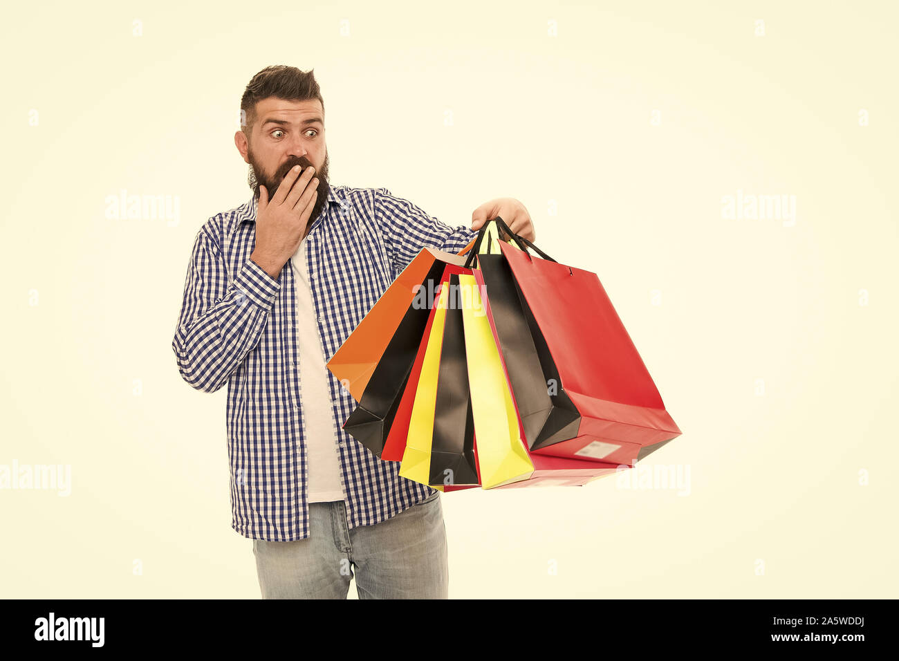 I survived Black Friday. Surprised hipster holding shopping bags after Black Friday isolated on white. Bearded man opening his shopping season on Black Friday. Offering deep discounts on Black Friday. Stock Photo