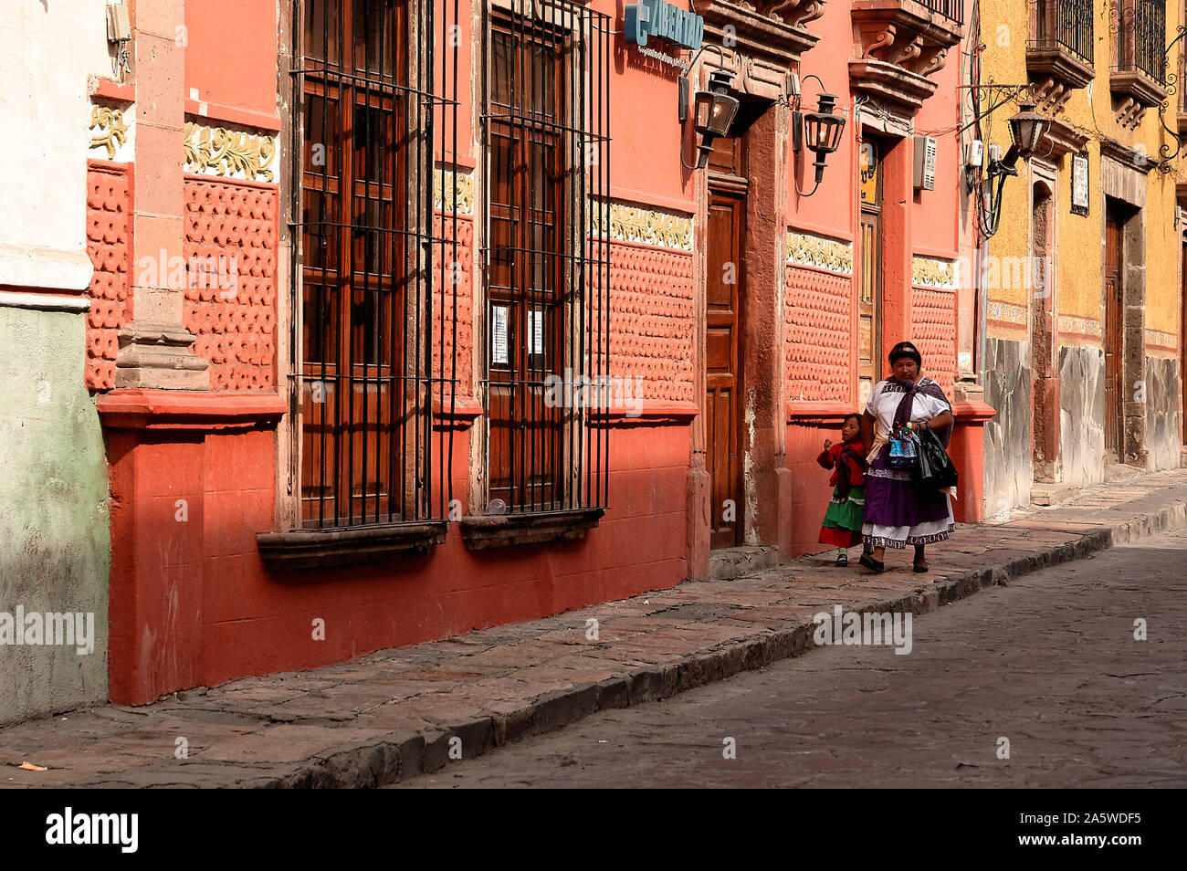 San Miguel de Allende, Guanajuato, Mexico - December 5, 2004: Woman and child in traditional costume walk down the street. Stock Photo