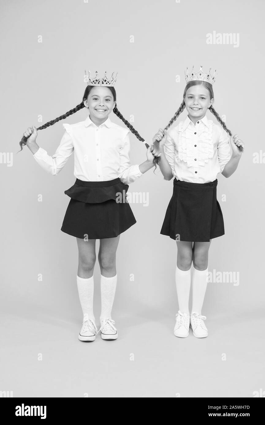 Brilliant pupils. Schoolgirls wear golden crowns symbol of respect. Award and respect. Cute princess. Motivational award for school children. Girls kids imaging luxury lifestyle. Award coronation. Stock Photo