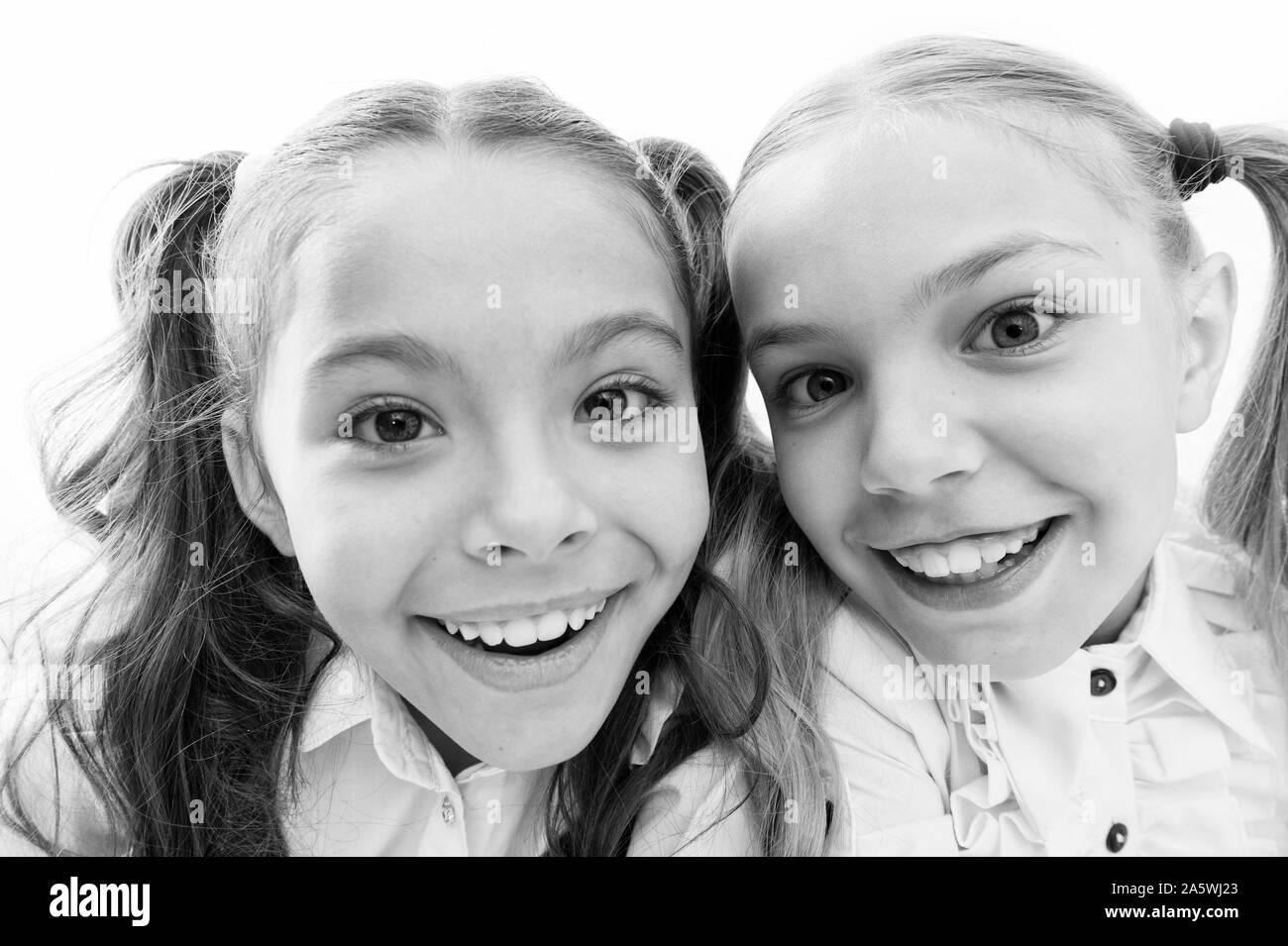 A whole new look. Happy school girls. Adorable little girls smiling isolated on white. Primary