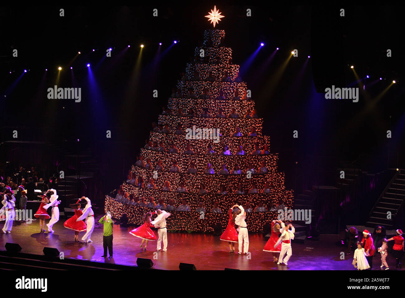 People dancing around a christmas tree hires stock photography and