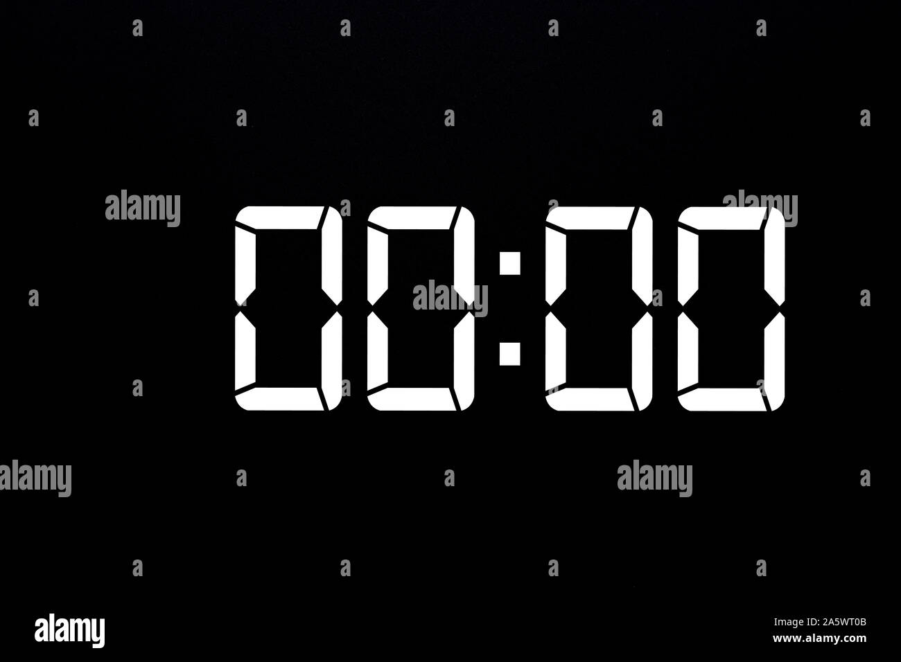Showing time 00:00 on white led digital clock isolated black background Stock Photo