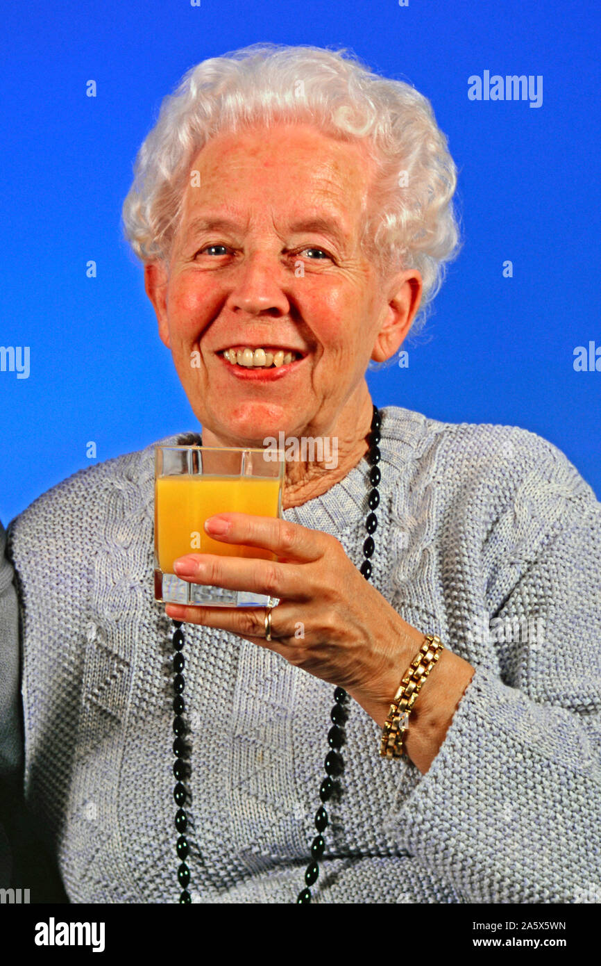 Senioren-Ehepaar trinkt Milch und Orangensaft - MR vorhanden Stock Photo