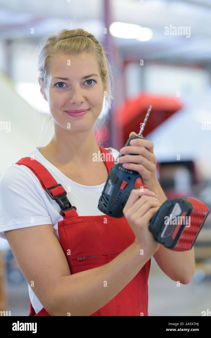 female engineer using drill in factory Stock Photo