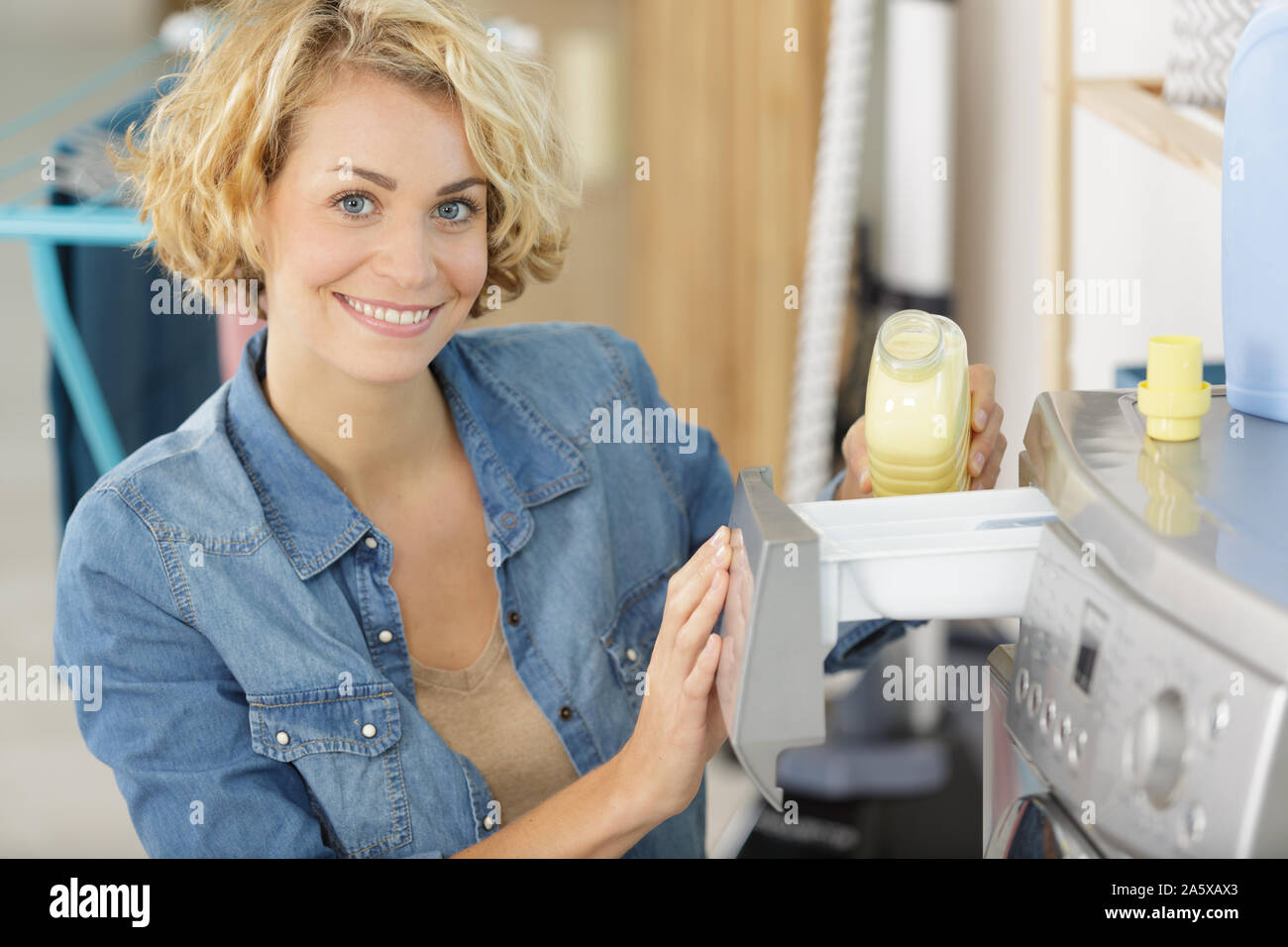 woman putting liquid detergent in the washing machine Stock Photo Alamy