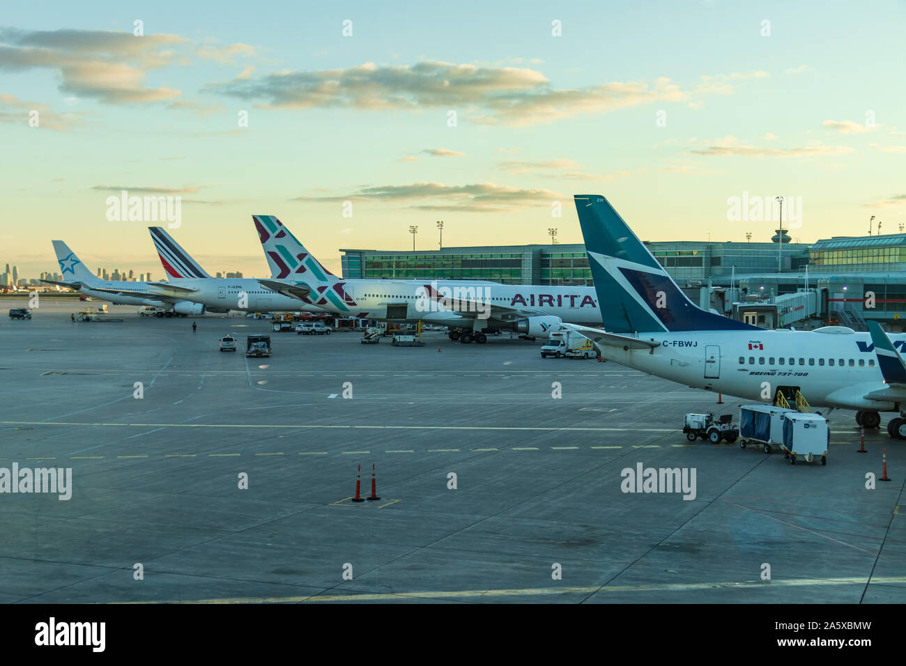 Four aircraft docked at gates at Toronto Pearson Intl. Airport, Terminal 1 during a beautiful sunset. Stock Photo