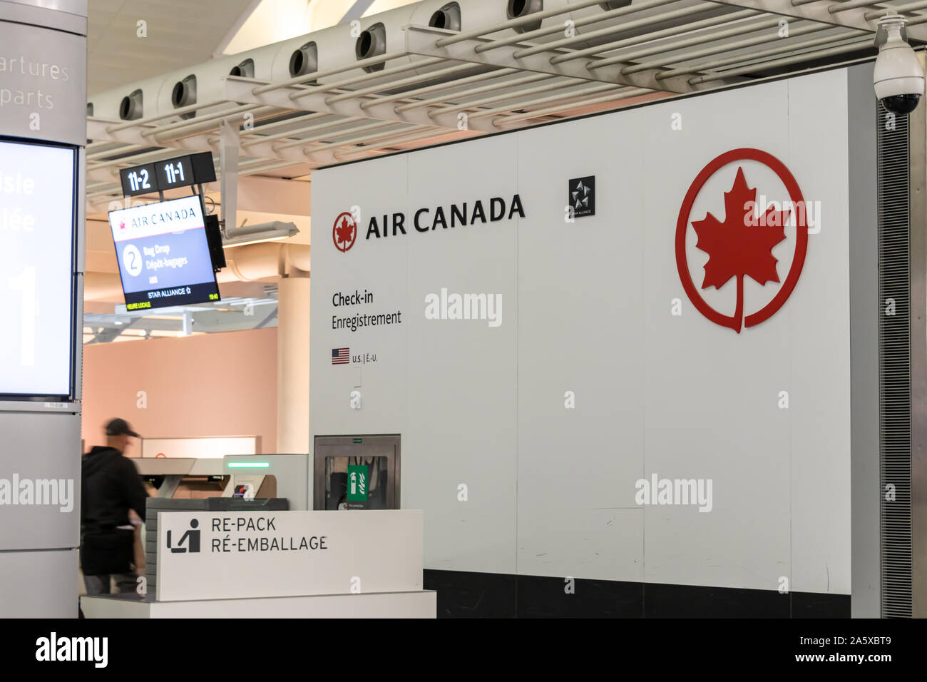Air Canada logo beside a check-in and bag drop kiosk inside Toronto Pearson Intl. Airport, Terminal 1. Stock Photo