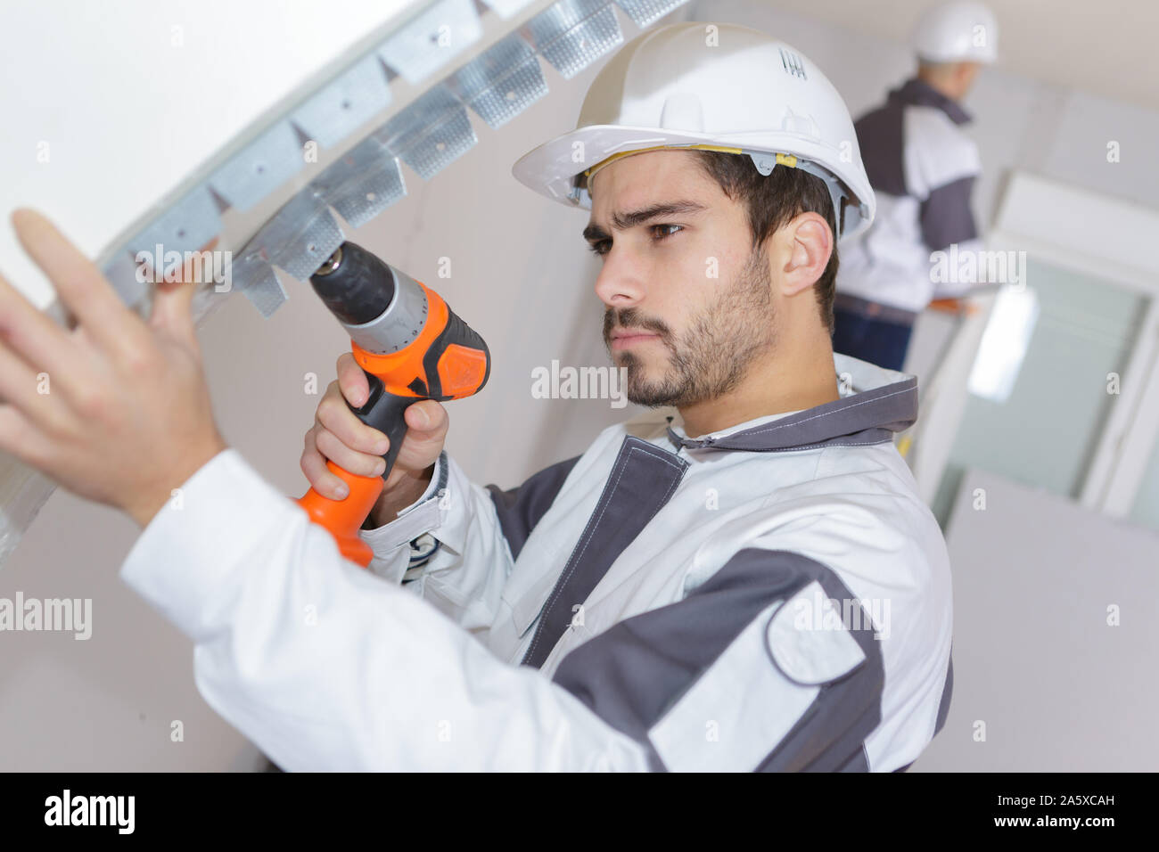 man working with drill indoors Stock Photo