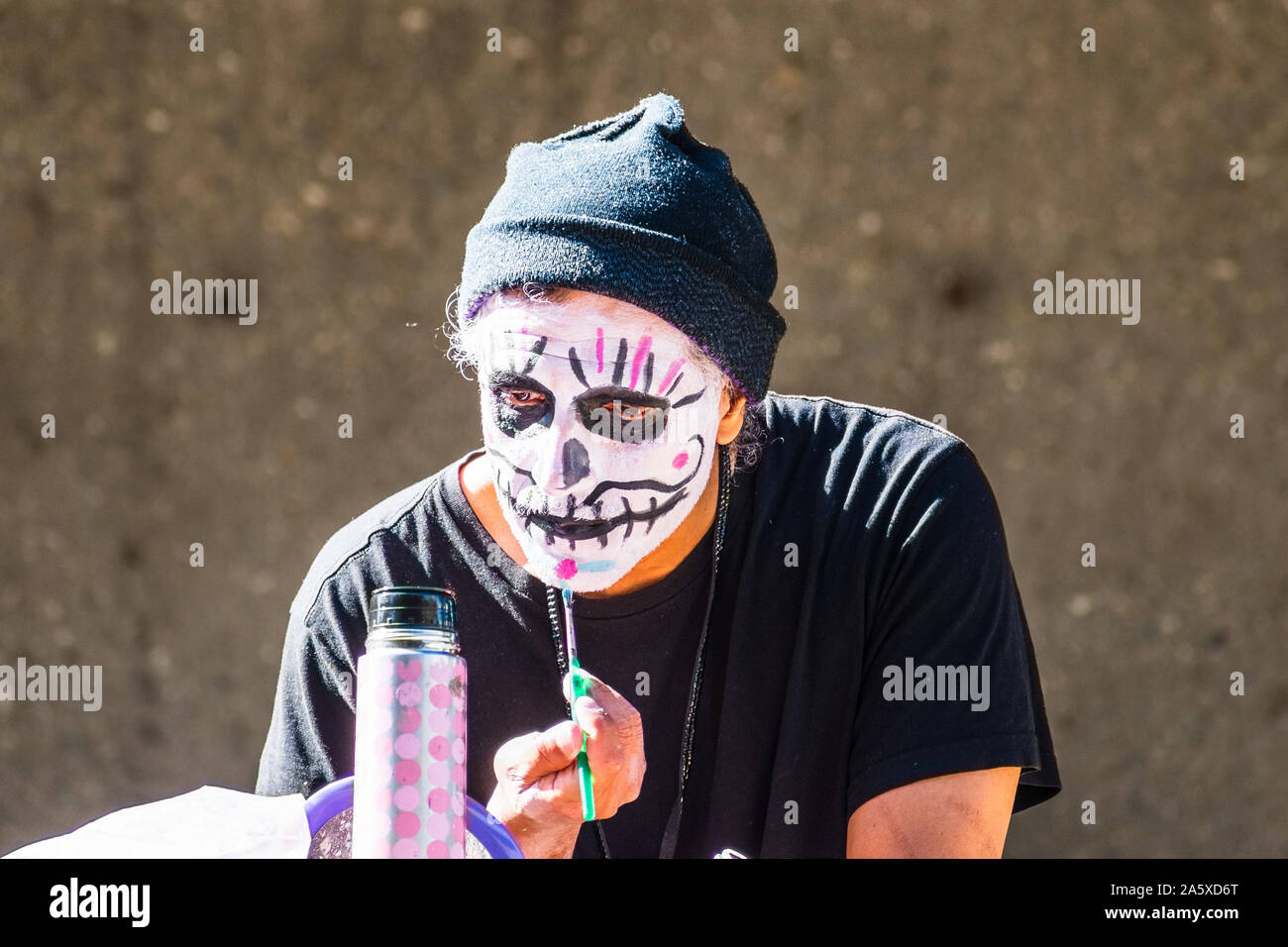 Oct 20, 2019 San Jose / CA / USA - Participant at Dia de Los Muertos (Day of the Dead) procession applying make-up and preparing for the event; South Stock Photo