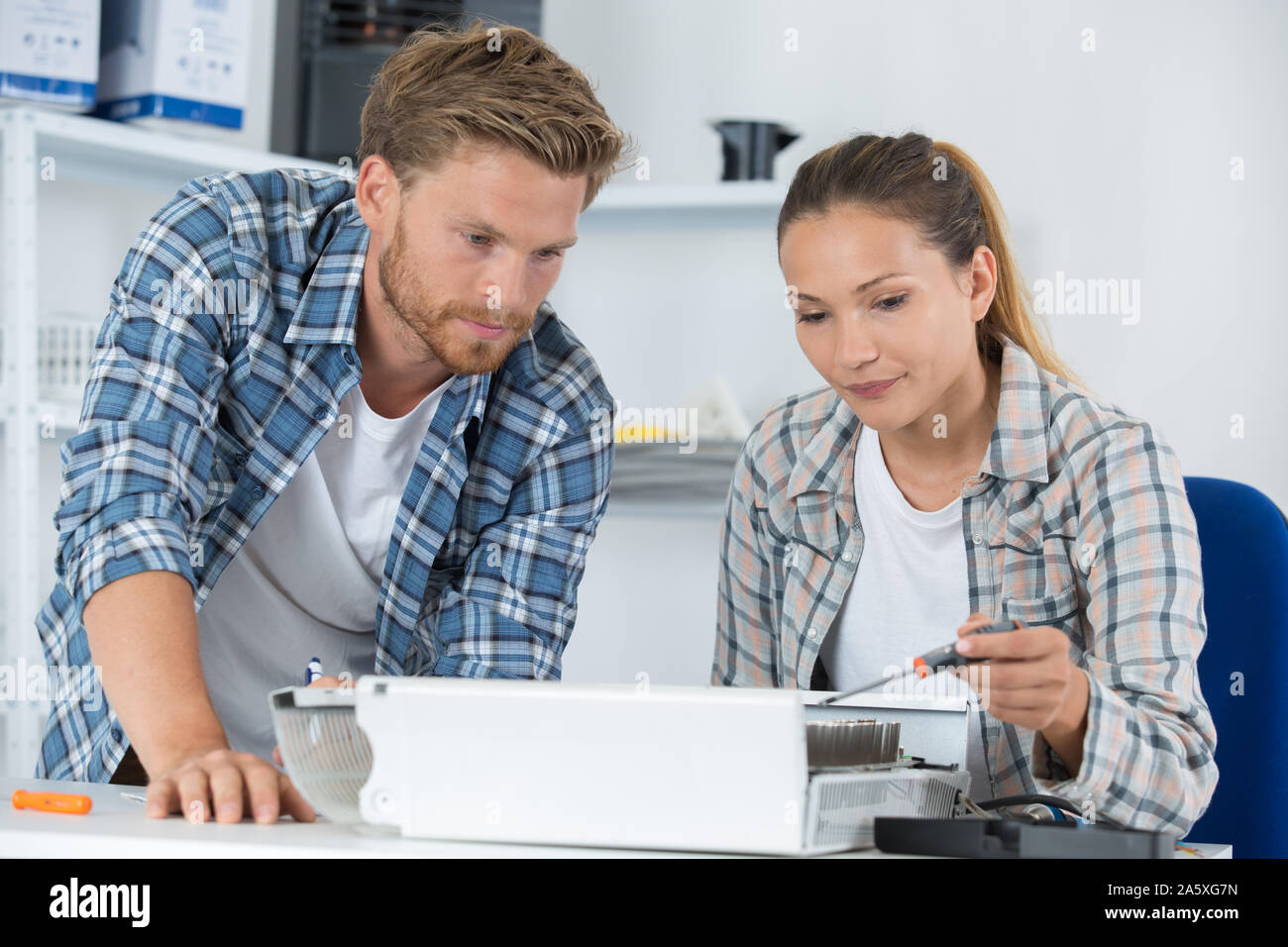 Plumber And Female Apprentice Fitting Central Heating System Stock