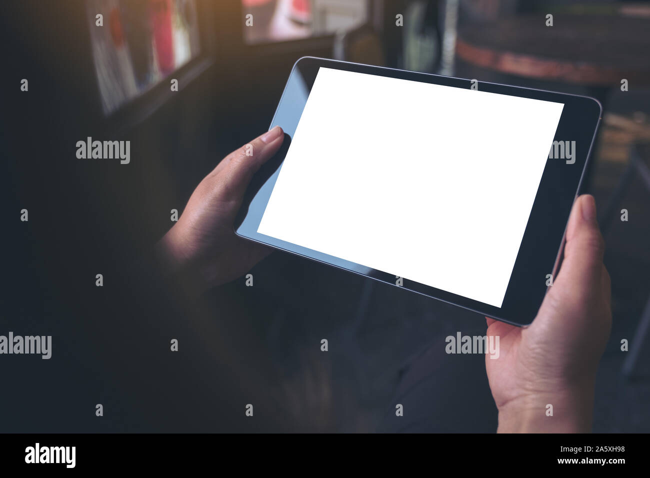 Mockup image of hands holding black tablet pc with blank white desktop ...
