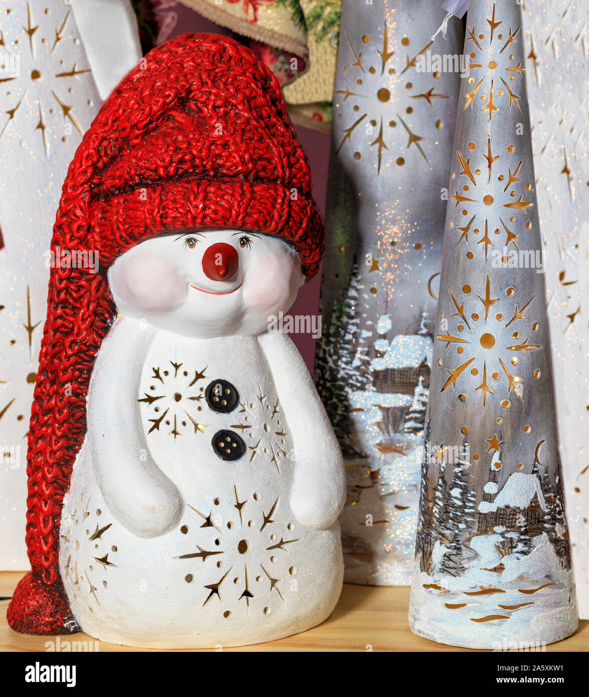 Decorative toy snowman in a long red knitted hat, on New Year's Eve against the background of New Year's Christmas caps. Stock Photo